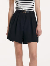 A lady wears black shorts with a belt.